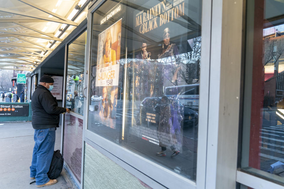 Charlton Ruddock purchases a ticket for "MLK/FBI" at the box office of the IFC Center, Friday, March 5, 2021, in New York. After growing cobwebs for nearly a year, movie theaters in New York City reopen Friday, returning film titles to Manhattan marquees that had for the last 12 months read messages like "Wear a mask" and "We'll be back soon." Cinemas in the city are currently operating at only 25% capacity, with a maximum of 50 per each auditorium. (AP Photo/Mary Altaffer)