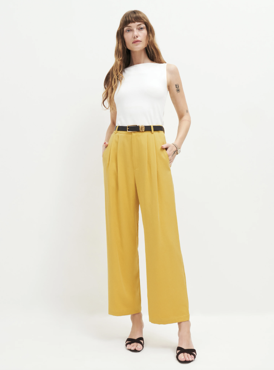 model wearing white sleeveless top and yellow Mason Cropped Pant (Photo via Reformation)