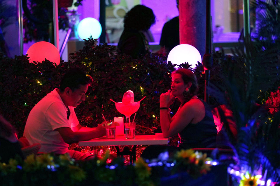 People dine outdoors along Ocean Drive, Friday, Sept. 24, 2021, in Miami Beach, Fla. Cooped-up tourists eager for a taste of Florida's sandy beaches, swaying palm trees and warmer climates are visiting the Sunshine State in droves, topping pre-pandemic levels in recent months. (AP Photo/Lynne Sladky)