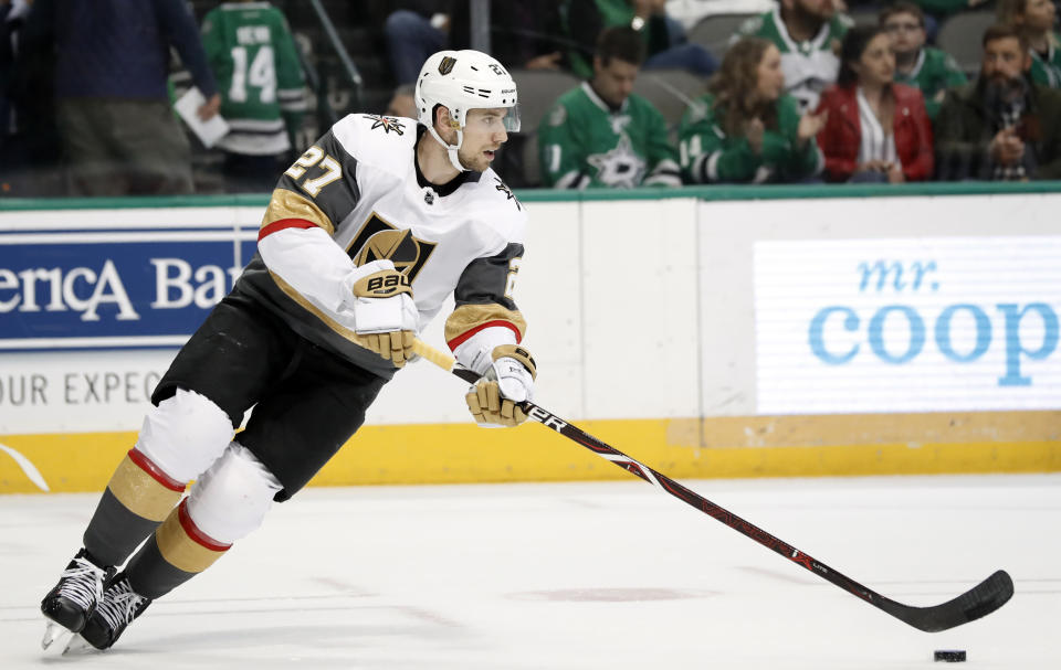 Vegas Golden Knights' Shea Theodore (27) moves the puck against the Dallas Stars during an NHL hockey game in Dallas, Friday, March 15, 2019. (AP Photo/Tony Gutierrez)
