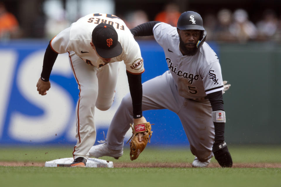 Chicago White Sox's Josh Harrison, right, slides safely into second base as San Francisco Giants second baseman Wilmer Flores lunges for an errant relay during the third inning of a baseball game, Sunday, July 3, 2022, in San Francisco. (AP Photo/D. Ross Cameron)