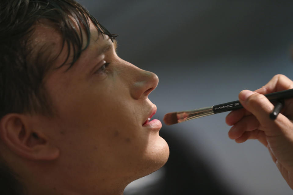 A model goes through make up in the backstage prior to the start of the Vivienne Westwood men's Spring-Summer 2014 fashion collection, part of the Milan Fashion Week, unveiled in Milan, Italy, Sunday, June 23, 2013. (AP Photo/Luca Bruno)