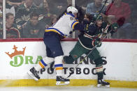 St. Louis Blues' Vladimir Tarasenko, left, checks Minnesota Wild's Jared Spurgeon into the boards during the first period of Game 2 of an NHL hockey Stanley Cup first-round playoff series Wednesday, May 4, 2022, in St. Paul, Minn. (AP Photo/Jim Mone)
