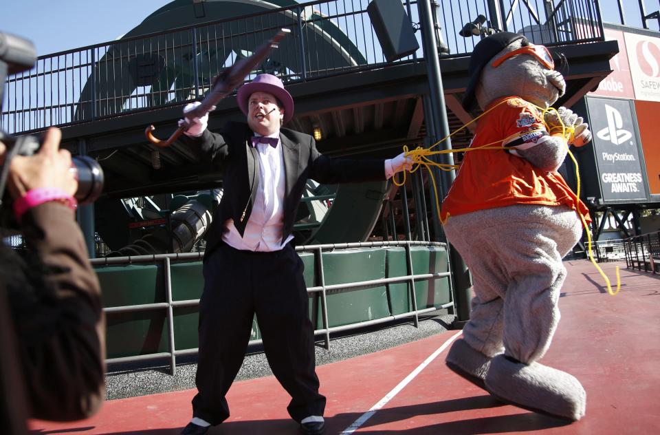 The Penguin holds the San Francisco Giants mascot Lou Seal captive as they wait for the arrival of five-year-old leukemia survivor Miles, aka "Batkid in San Francisco