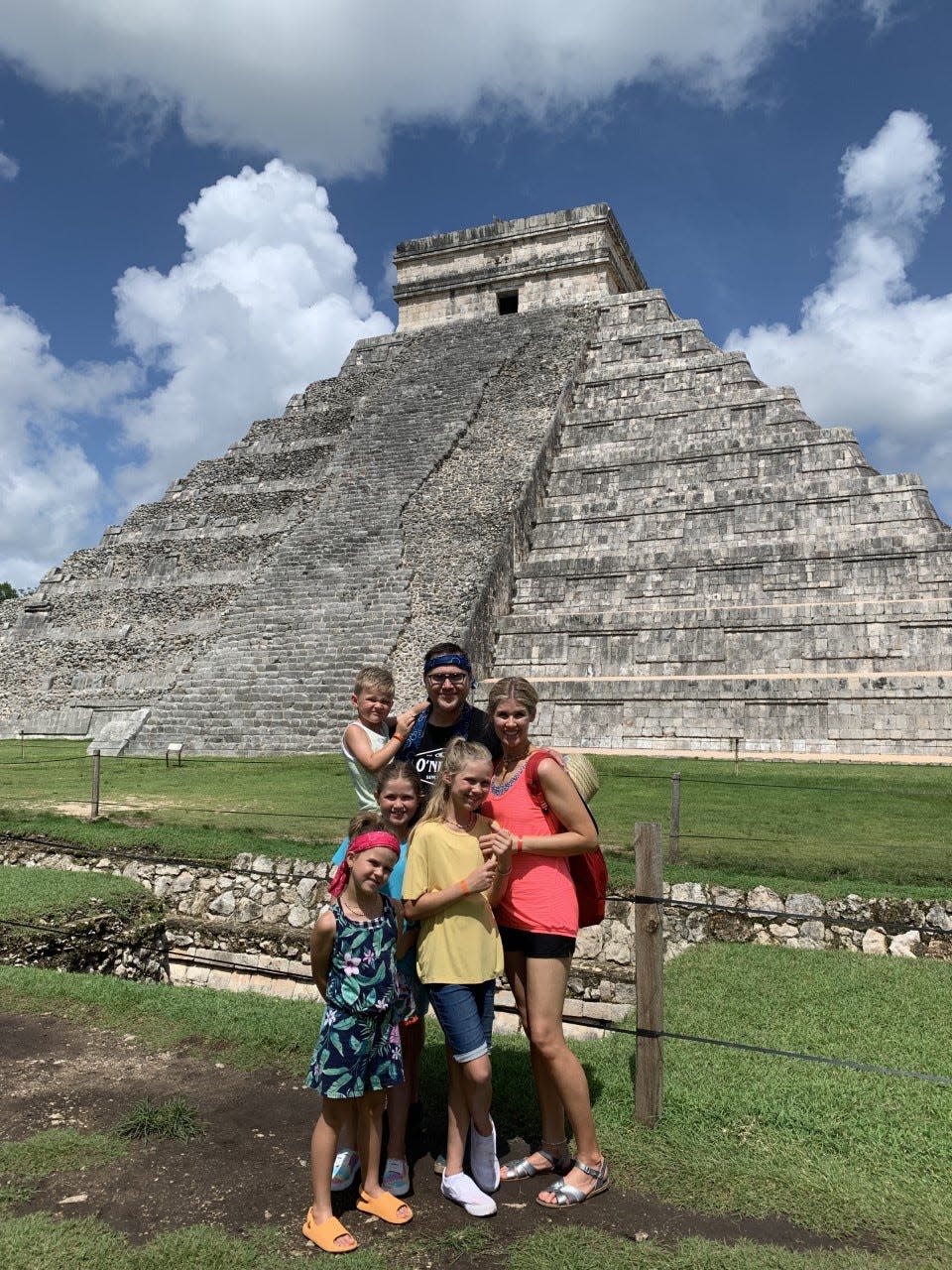 A family of six posing in front of the El Castillio pyramid at Chichén Itzá in Mexico.