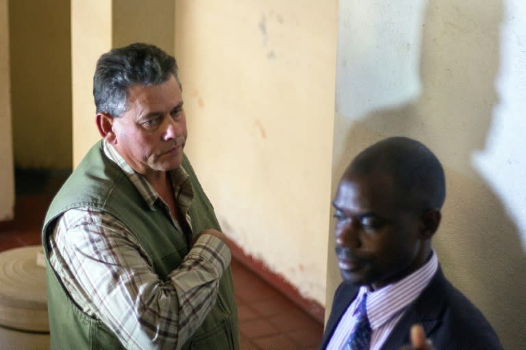 Zimbabwean hunter Theo Bronkhorst (left) and his defence lawyer wait outside the Magistrate's Court in Hwange, on July 29, 2015