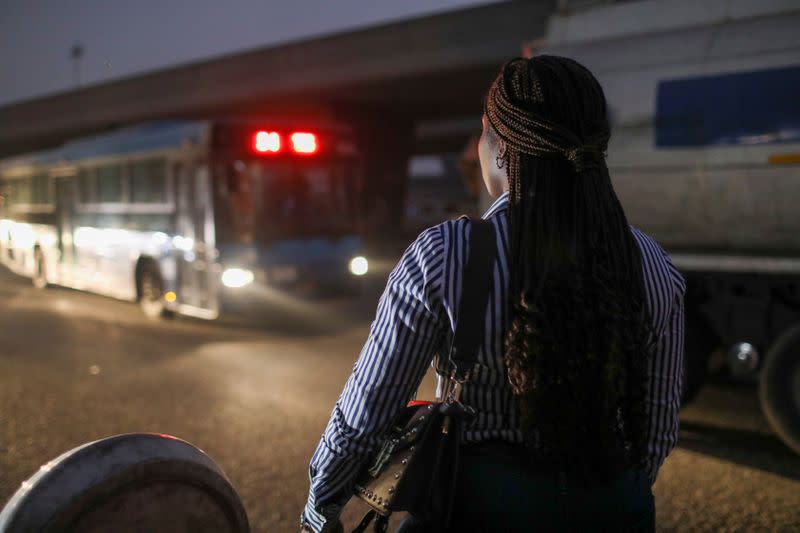Abisoye Adeniyi, 23, stands by the roadside as she awaits a bus in Lagos