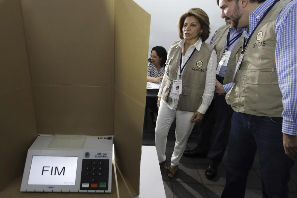 Head of the OAS Electoral Observation Mission and Former President of Costa Rica, Laura Chinchilla, accompanied by a observer, visit a polling station in Brasilia, Brazil, Sunday, Oct. 28, 2018. Jair Bolsonaro, presidential candidate with the Social Liberal Party, is running against leftist candidate Fernando Haddad of the Workers' Party. (AP Photo/Eraldo Peres)