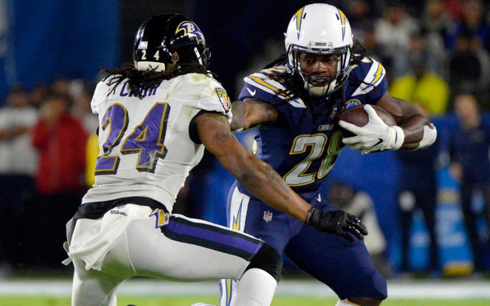 Chargers running back Melvin Gordon hands off Ravens cornerback Brandon Carr - USA TODAY Sports