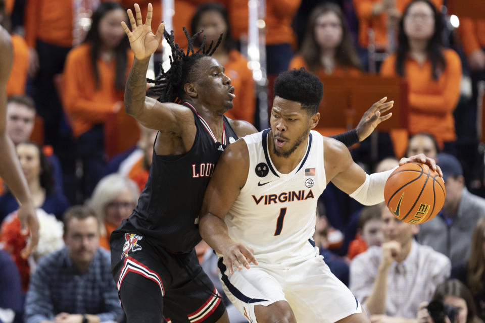 Virginia's Jayden Gardner (1) is defended by Louisville's Mike James (1) during the first half of an NCAA college basketball game in Charlottesville, Va., Saturday, March 4, 2023. (AP Photo/Mike Kropf)