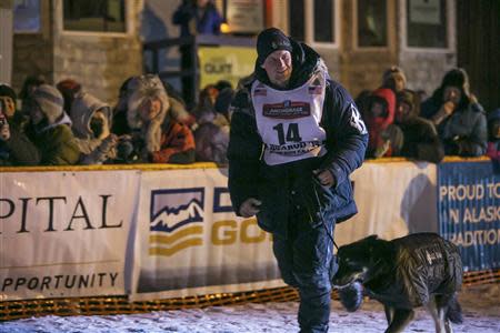 Dallas Seavey runs with his lead dog after greeting the crowd gathered at the finish line at 4am after winning the Iditarod dog sled race in Nome, Alaska, March 11, 2014. REUTERS/Nathaniel Wilder