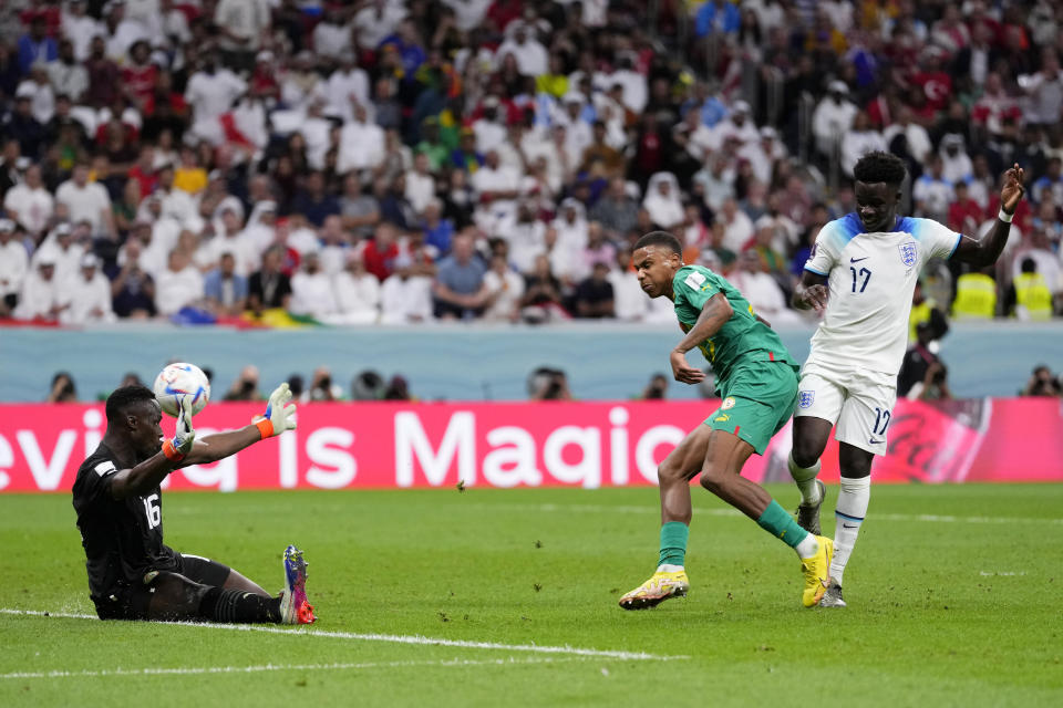 England's Bukayo Saka, right, scores his side's third goal during the World Cup round of 16 soccer match between England and Senegal, at the Al Bayt Stadium in Al Khor, Qatar, Sunday, Dec. 4, 2022. (AP Photo/Manu Fernandez)