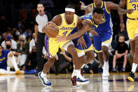 Los Angeles Lakers guard Rajon Rondo (4) and Golden State Warriors forward Andrew Wiggins (22) vie for the ball during the first half of an NBA basketball game in Los Angeles, Tuesday, Oct. 19, 2021. (AP Photo/Ringo H.W. Chiu)