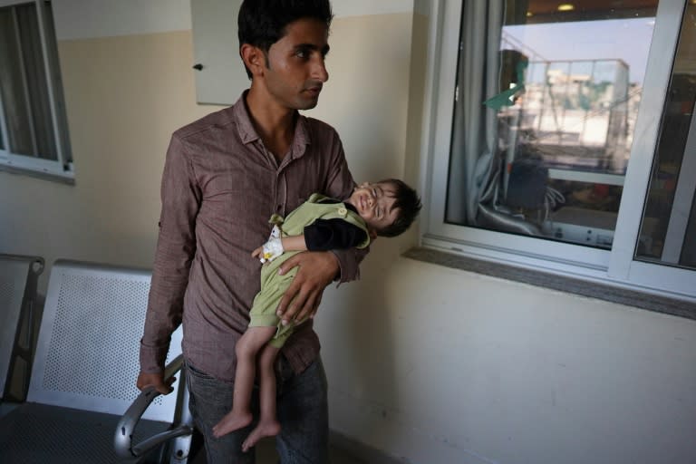 Palestinian children suffering malnutrition or chronic diseases wait with family members in the southern Gaza Strip after they reportedly received permission from the Israeli army to leave the besieged Palestinian territory (Bashar TALEB)