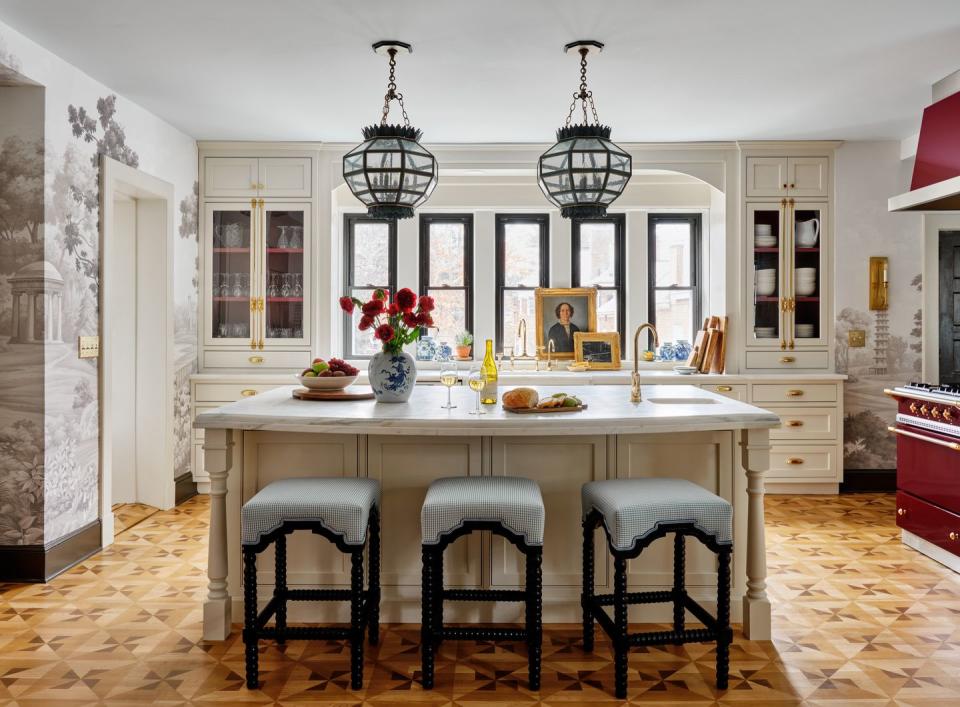 kitchen in a hartford\, connecticut\, home designed by interior designer kristen mccory deep burgundy lacanche range and hood pegasus marble countertops, linen white cabinetry paint, and black accents temper the red, while painted, parquet like floors and a sepia english garden mural