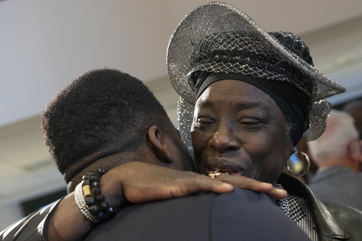 Marian Markelo, a Winti Priest, an Afro-Surinamese traditional religion, right, is hugged after Dutch Prime Minister Mark Rutte apologized on behalf of his government for the Netherlands’ historical role in slavery and the slave trade at the National Archives in The Hague, Monday, Dec. 19, 2022. (AP Photo/Peter Dejong)