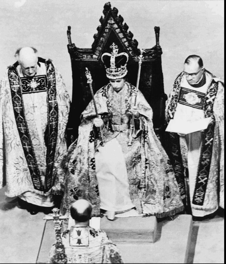 FILE - The Archbishop of Canterbury, foreground, reads the Benediction to Queen Elizabeth II, wearing St. Edward's Crown, during her coronation ceremony, in London, June 2, 1953. The crowning moment of King Charles III's coronation ceremony will occur, literally, when the Archbishop of Canterbury places St. Edward’s Crown on King Charles’ head. Because of its significance as the centerpiece of the coronation, this will be the only time during his reign that the monarch will wear the solid gold crown, which features a purple velvet cap, ermine band and criss-crossed arches topped by a cross. (AP Photo, File)