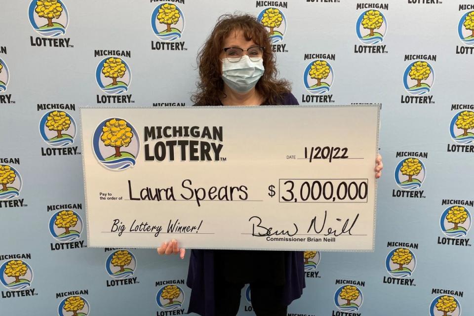 Lotto winner holds lottery prize cheque for $3 million