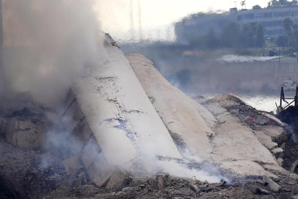 Smoke rises from part of the collapsed silos damaged during the August 2020 massive explosion in the port, in Beirut, Lebanon, Thursday, Aug. 4, 2022. A large section of the silos collapsed on Thursday as hundreds marched in Beirut to mark the second anniversary of the blast that killed scores. (AP Photo/Hussein Malla)