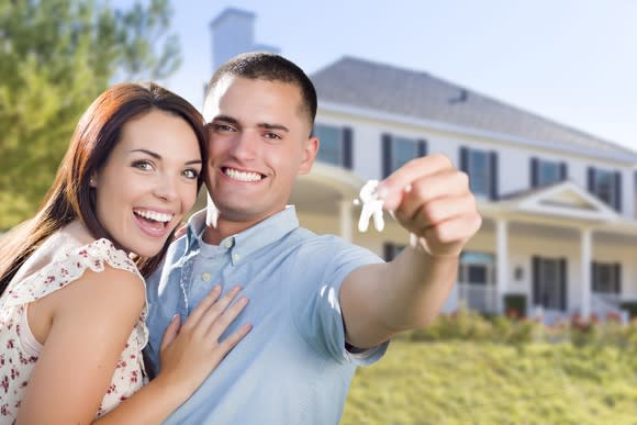 A couple showing keys to their new house