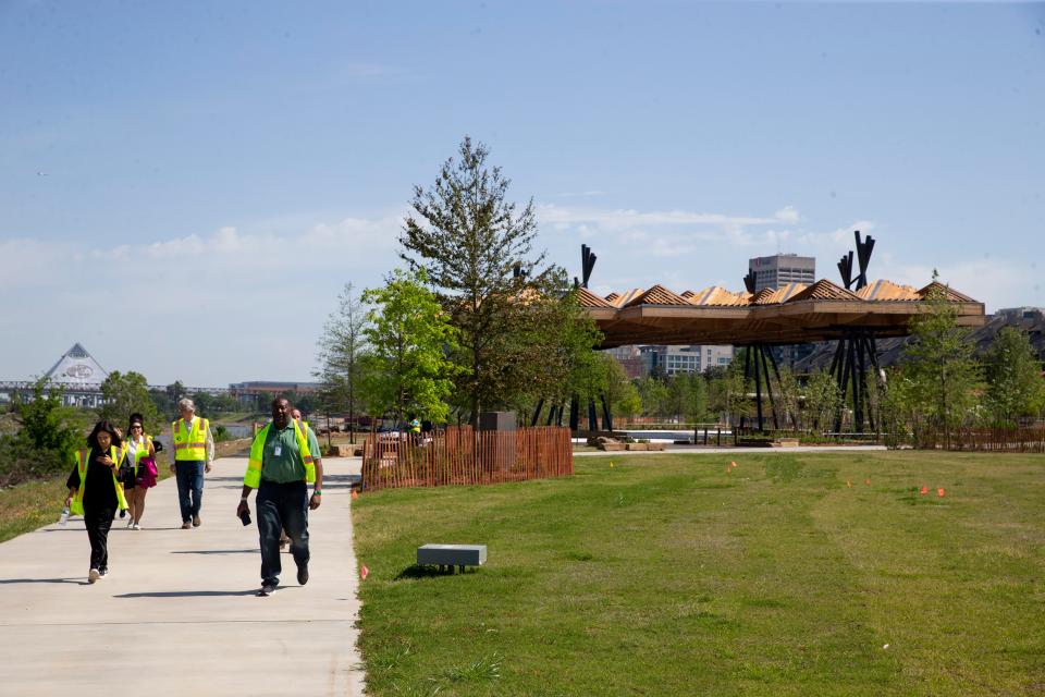 Members of multiple Downtown Memphis Commission boards and the media tour Tom Lee Park as they walk away from the Sunset Canopy and view some of the 1,000 new trees that have been planted in the park in Downtown Memphis, on Tuesday, April 18, 2023. The park is set to open this summer after a $60 million-plus renovation. 