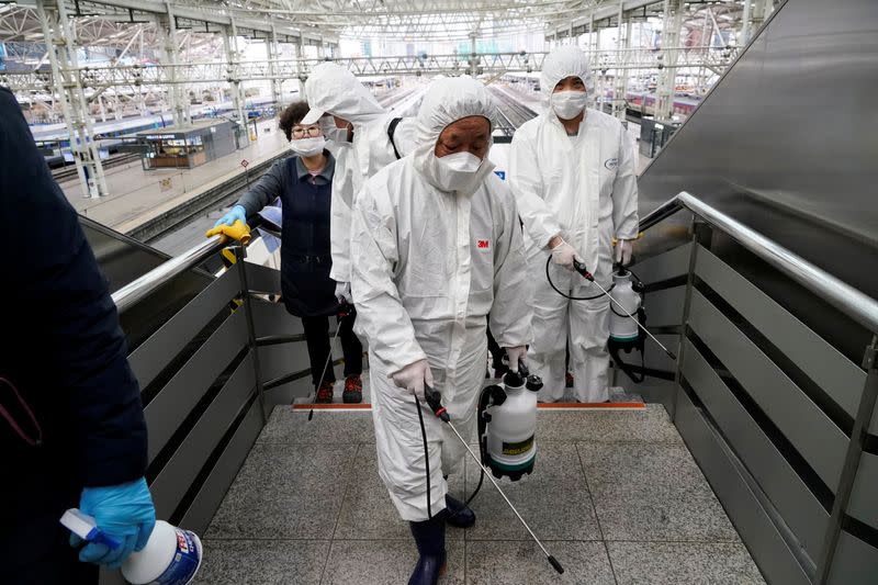Employees from a disinfection service company sanitize the floor of Seoul Railway Station in Seoul