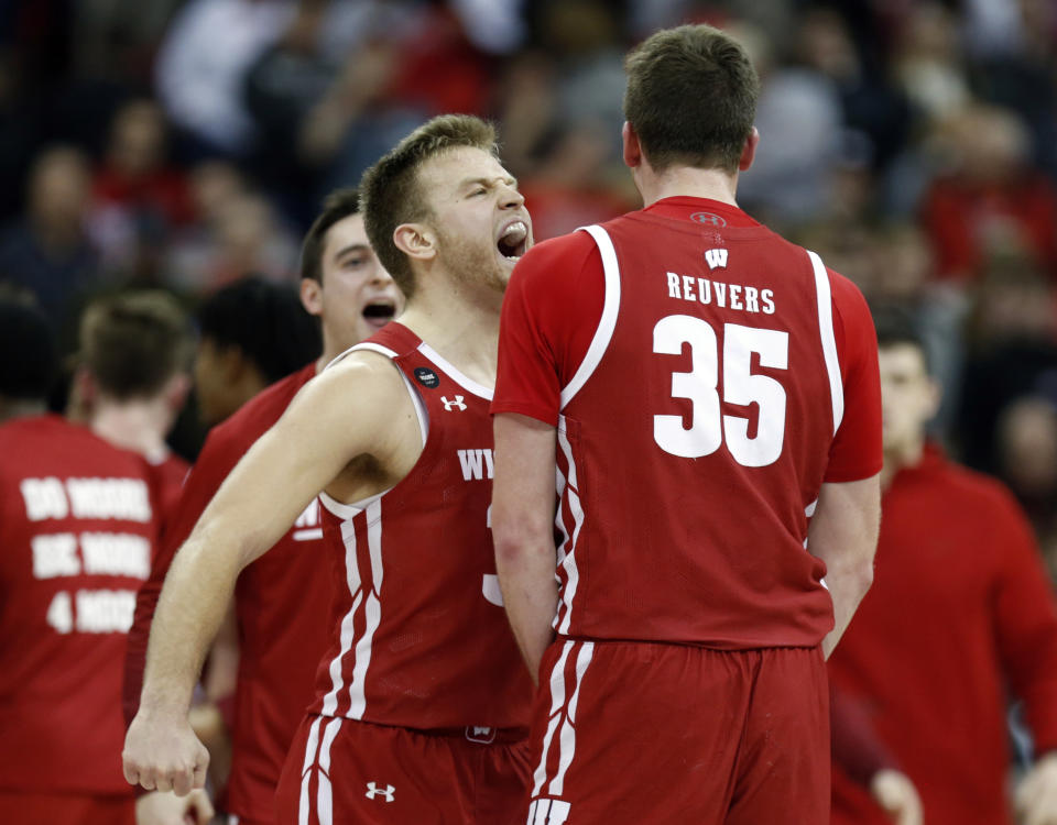 Wisconsin guard Brad Davison, left, celebrates with teammate forward Nate Reuvers during the final seconds of the second half of an NCAA college basketball game against Ohio State in Columbus, Ohio, Friday, Jan. 3, 2020. (AP Photo/Paul Vernon)