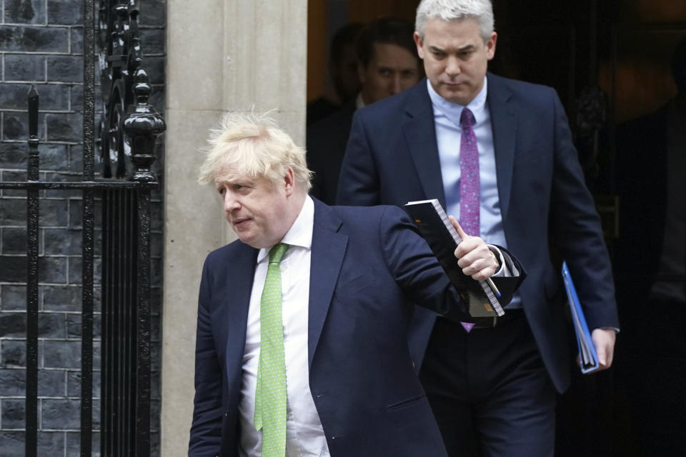 Prime Minister Boris Johnson followed by Downing Street Chief of Staff Steve Barclay, right, leave Downing Street to update members of Parliament in the House of Commons with the latest developments regarding Ukraine, in London, Tuesday, Feb. 22, 2022. Johnson says the U.K. will introduce “immediate” economic sanctions against Russia, and warned that President Vladimir Putin is bent on “a full-scale invasion of Ukraine.” (Joe Cook/PA via AP)