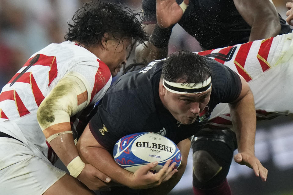 England's Jamie George, drives forward as he is tackled by Japan's Keita Inagaki, left, during the Rugby World Cup Pool D match between England and Japan in the Stade de Nice, in Nice, France Sunday, Sept. 17, 2023. (AP Photo/Pavel Golovkin)