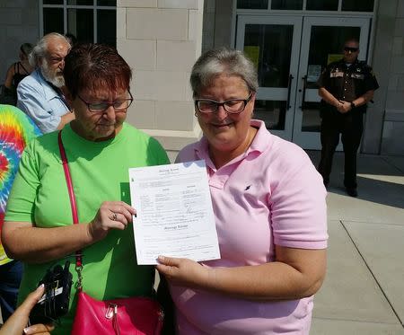 April Miller (R) and Karen Roberts speak outside the county clerk's office after obtaining a marriage license in Morehead, Kentucky, September 4, 2015. REUTERS/Steve Bittenbender