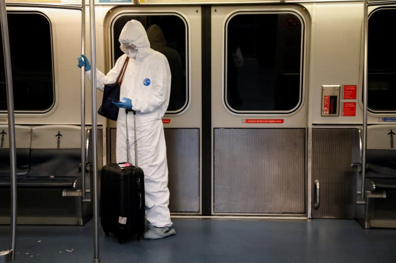 A woman wears personal protective equipment (PPE) as she rides the air-train at John F. Kennedy International Airport in New York