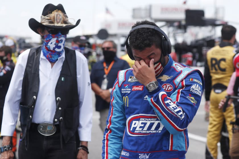 Driver Bubba Wallace, right, is overcome with emotion as he and team owner Richard Petty walk to his car in the pits of the Talladega Superspeedway prior to the start of the NASCAR Cup Series auto race at the Talladega Superspeedway in Talladega Ala., Monday June 22, 2020. In an extraordinary act of solidarity with NASCAR's only Black driver, dozens of drivers pushed the car belonging to Bubba Wallace to the front of the field before Monday's race as FBI agents nearby tried to find out who left a noose in his garage stall over the weekend. (AP Photo/John Bazemore)