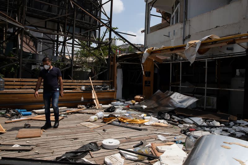 Owner Nazih Dirani walks among debris at the damaged "Coup d'Etat" bar, in the aftermath of a massive explosion at the port area, in Beirut