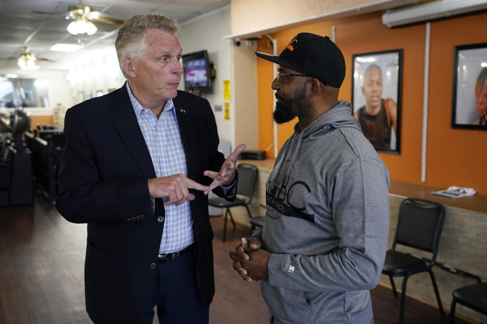 Democratic gubernatorial candidate, former Gov. Terry McAuliffe, left, talks with Wes Nicholas during a tour of downtown Petersburg, Va., Saturday, May 29, 2021. McAuliffe restored Nicholas's voting rights in 2015. McAuliffe faces four other Democrats in the a primary June 8. (AP Photo/Steve Helber)