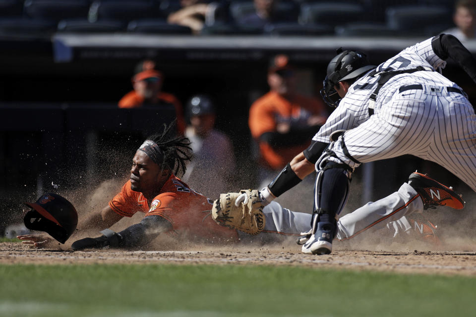 Baltimore Orioles' Cedric Mullins scores a run past New York Yankees catcher Kyle Higashioka during the seventh inning of a baseball game on Saturday, Sept. 4, 2021, in New York. (AP Photo/Adam Hunger)