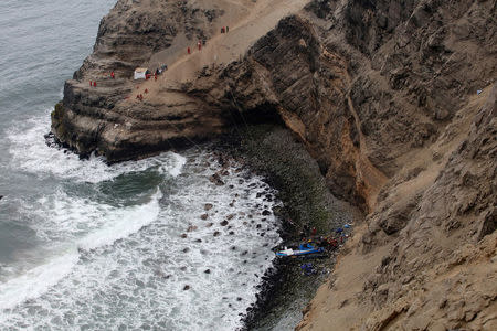 Rescue workers work at the scene after a bus crashed with a truck and careened off a cliff along a sharply curving highway north of Lima, Peru, January 3, 2018. REUTERS/Guadalupe Pardo