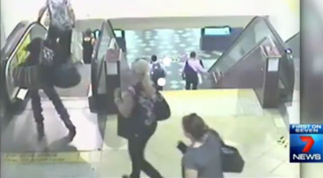 This guy with with bags is moments from toppling over on the escalator. Photo: 7 News