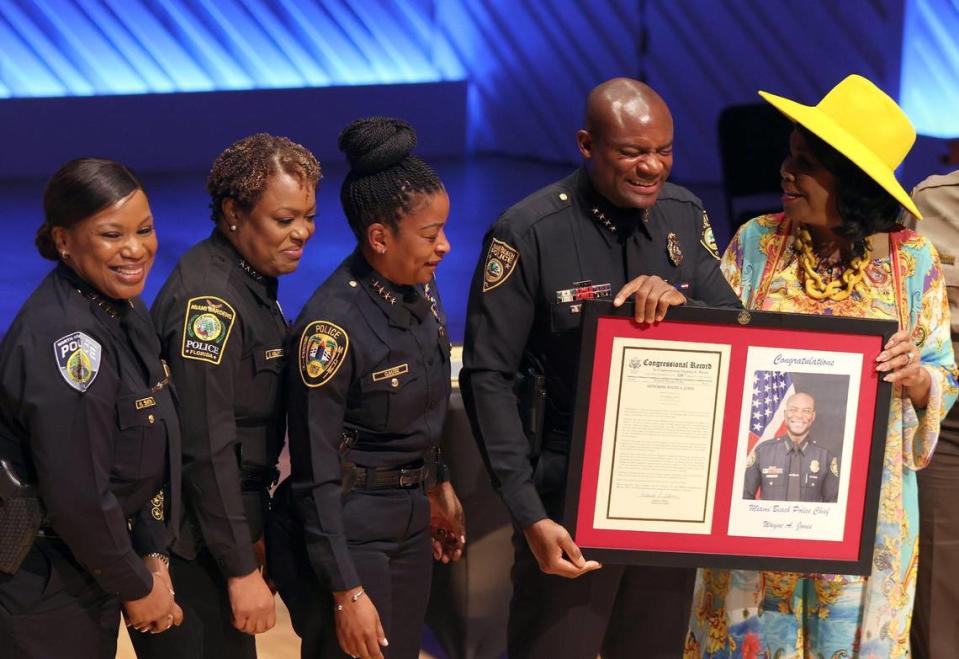Police chiefs Harvette Smith, of North Miami Beach, left, Delma Noel-Pratt, of Miami Gardens, and Cherise Gause, of North Miami, look on as new Miami Beach Police Chief Wayne Jones receives a proclamation to be placed in the Congressional Record from U.S. Rep. Frederica Wilson, right.