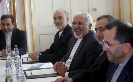 Iranian Foreign Minister Javad Zarif (C) laughs during a meeting with U.S. Secretary of State John Kerry (not pictured) at a hotel in Vienna, Austria June 30, 2015. REUTERS/Carlos Barria