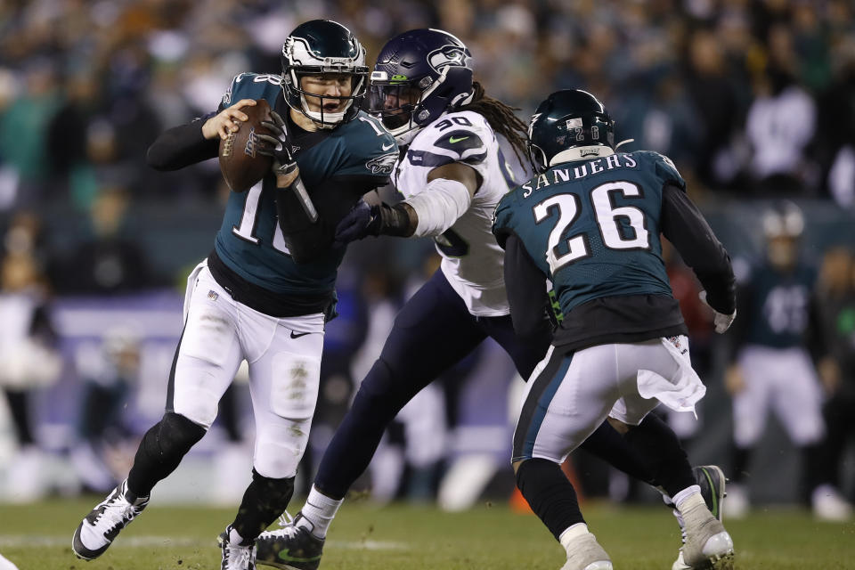 Philadelphia Eagles' Josh McCown (18) tries to get past Seattle Seahawks' Jadeveon Clowney (90) as Miles Sanders (26) tries to defend during the first half of an NFL wild-card playoff football game, Sunday, Jan. 5, 2020, in Philadelphia. (AP Photo/Matt Rourke)