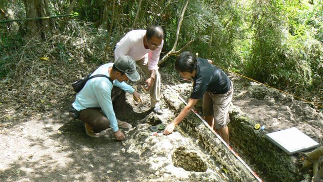 In this Feb. 26, 2011 photo released by the Philippine National Museum, Filipino archeologists gather items around a limestone coffin at Mount Kamhantik, near Mulanay town in Quezon province, eastern Philippines. Archeologists have unearthed remnants of what they believe is a 1,000-year-old village on the jungle-covered mountaintop in the Philippines with limestone coffins of a type never before found in this Southeast Asian nation, officials said, Thursday, Sept. 20, 2012. (AP Photo/Philippine National Museum, Joe Santiago) EDITORIAL USE ONLY, NO SALES