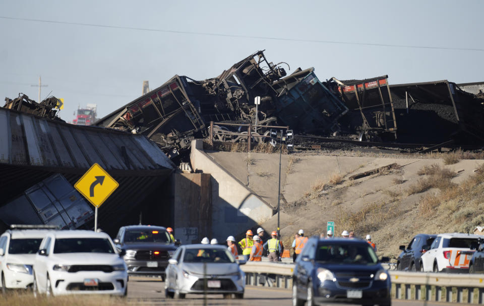 Workers toil to clear cars that derailed in an accident over Interstate 25 northbound, Monday, Oct. 16, 2023, north of Pueblo, Colo. (AP Photo/David Zalubowski)