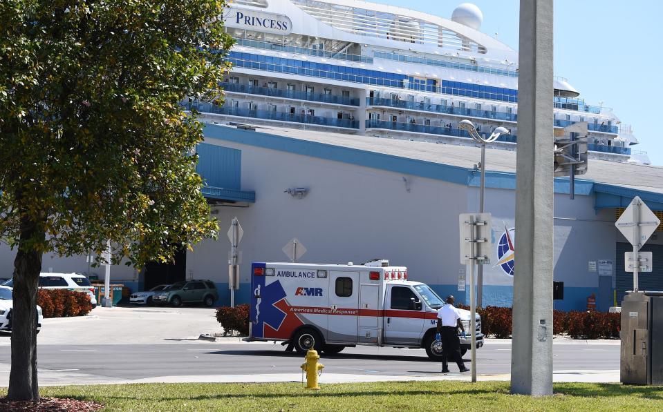 An ambulance takes a patient from the cruise ship Coral Princess to the hospital as the ship is docked at the Port of Miami, Florida