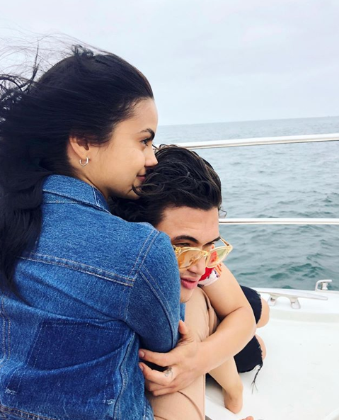 A photo of Riverdale couple Camila Mendes and Charles Melton sharing a hug on a boat