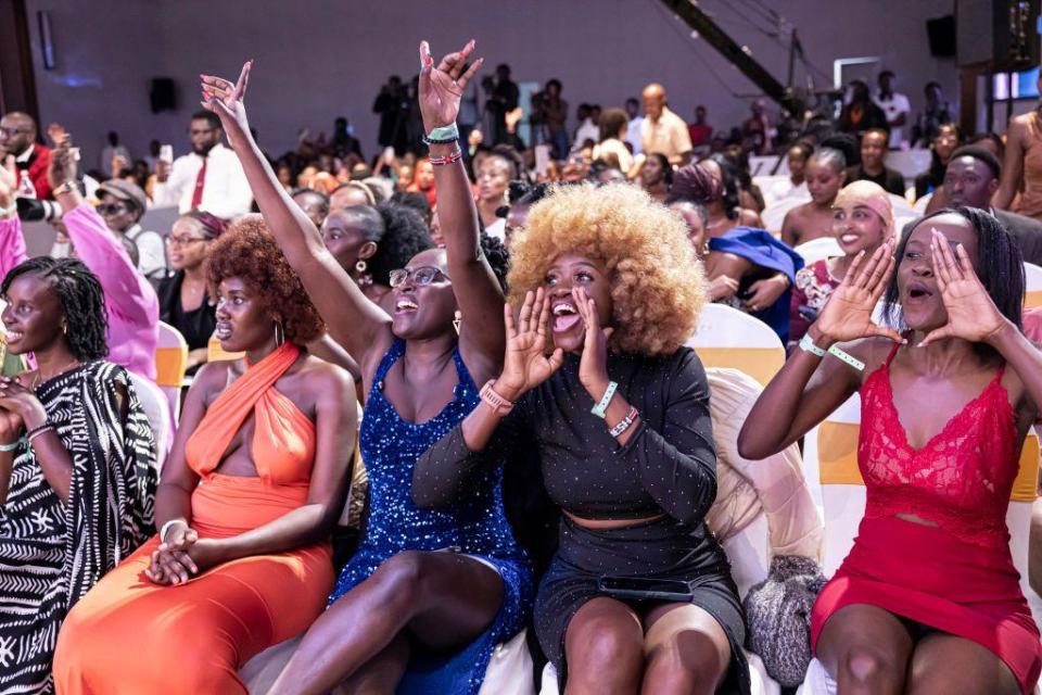 Women sat on the front row cheer and shout in encouragement.