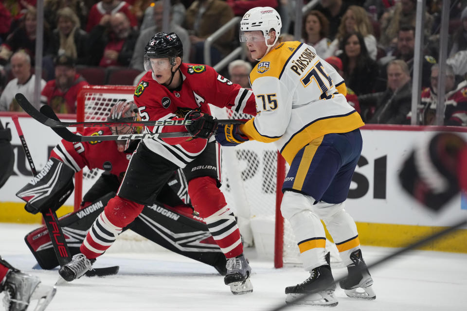 Nashville Predators center Juuso Parssinen, right, and Chicago Blackhawks defenseman Connor Murphy clash in front of the Blackhawks' net during the first period an NHL hockey game Tuesday, Dec. 5, 2023, in Chicago. (AP Photo/Erin Hooley)