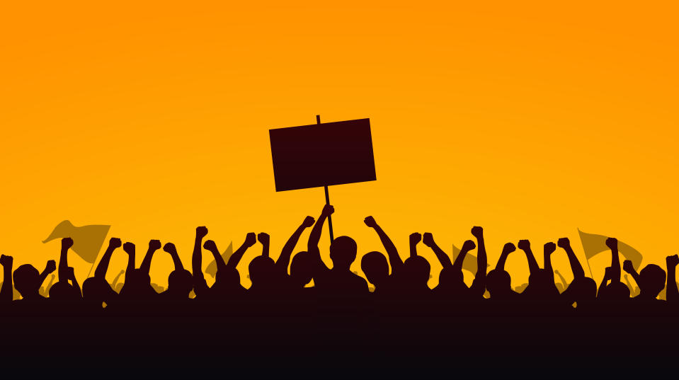 Silhouette group of people Raised Fist and Protest Signs in yellow evening sky background