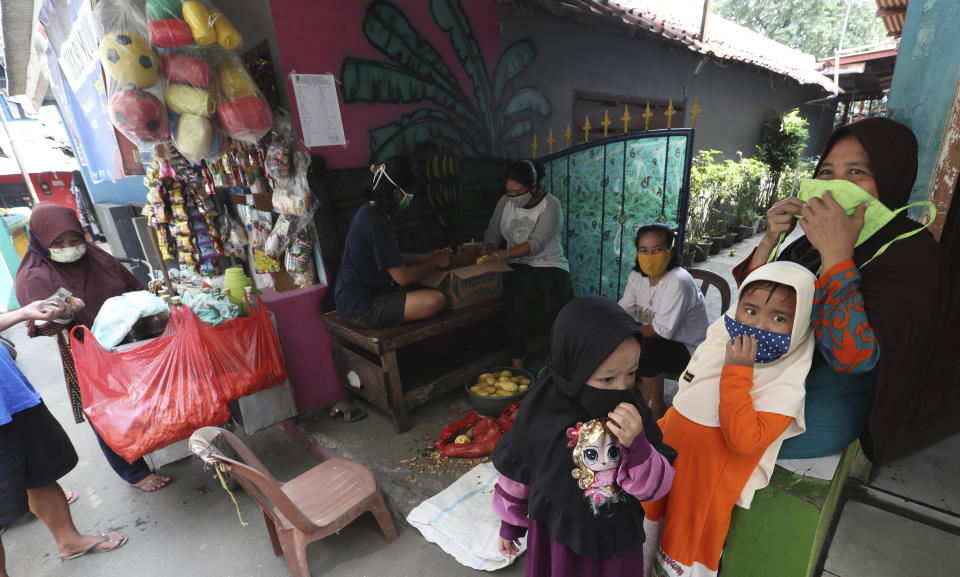 Villagers wear face masks to help curb the spread of the new coronavirus as they gather at Rawa Pasung village in Bekasi on the outskirts of Jakarta, Indonesia, Thursday, July 23, 2020. (AP Photo/Achmad Ibrahim)