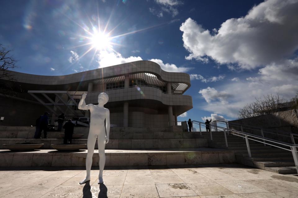 A sculpture of a naked boy stands on a concrete patio.