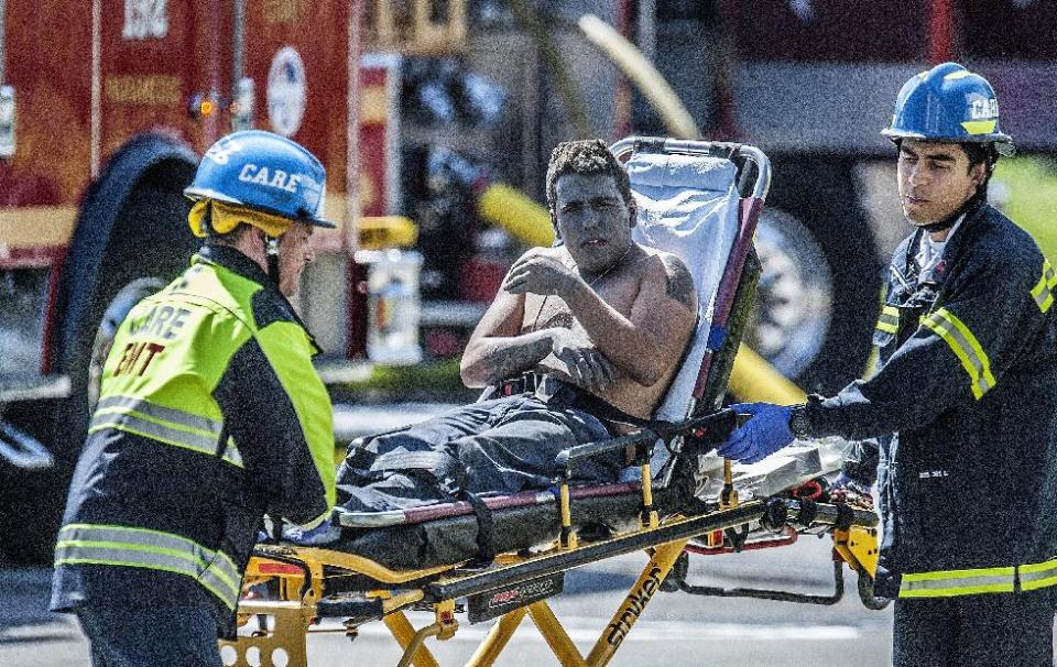 An injured worker is moved toward a waiting ambulance after an explosion was reported at a business in La Habra, Calif., Tuesday, April 29, 2014. Authorities say eight people have been hurt, three critically, in an explosion and fire at a commercial building in south Los Angeles County. (AP Photo/The Orange County Register, Bruce Chambers)